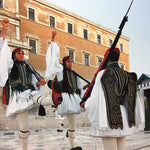 Evzones, Greek Presidential guards, shown in mid-stride with their uniforms.